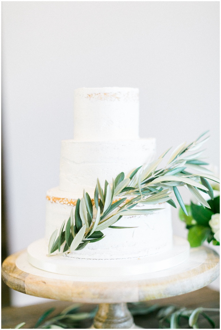 simple white wedding cake with olive branch details