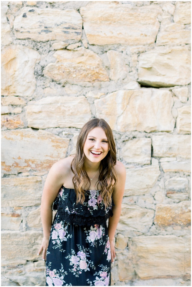 girl leaning against a wall laughing, image by jody Atkinson photography