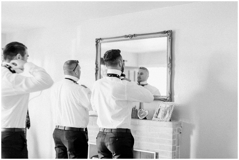 groomsmen getting ready in front of a big mirror, sunol California wedding at nella terra cellars captured by jody Atkinson photography