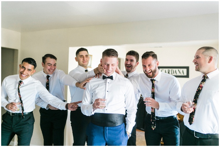groomsmen giving the groom a hard time while getting ready