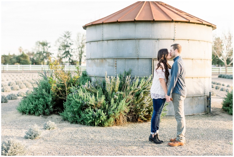 couple kissing in front of a Rustic metal building