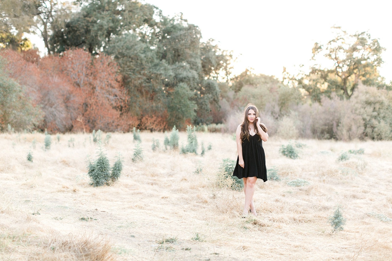 girl in a black dress standing in a field