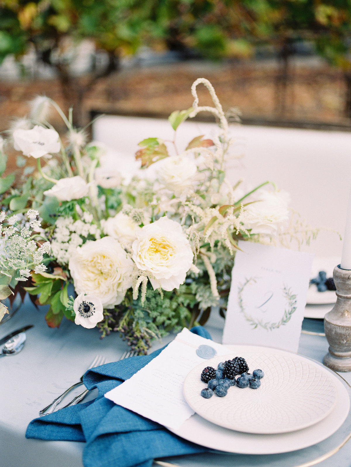 blue and white wedding reception table with blue berries and black berries